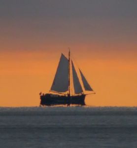Die Onverwacht segelt im Sonnenuntergang